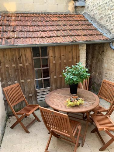 a wooden table and chairs on a patio at Private house with a view on Bayeux's Cathedrale in Bayeux