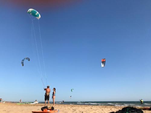 a group of people flying kites on the beach at MAYANA SICILY - The suites in Santa Maria Del Focallo