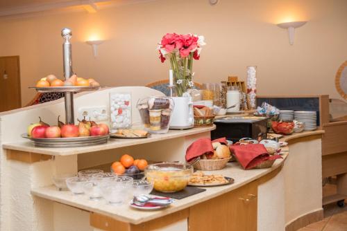 a breakfast buffet with fruit and other food on a counter at Hotel Kalma in Hévíz
