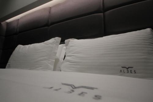 a bed with two white pillows on top of it at Albes Hotel in Fier