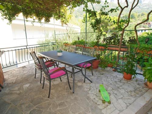 una mesa y sillas en un patio en Apartmani Danica, en Gradac