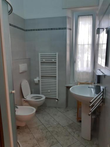 een badkamer met een wit toilet en een wastafel bij Parma Holiday 2020+21 in Parma