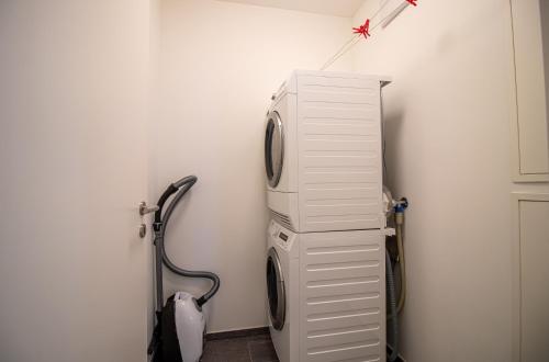 a room with a white refrigerator and a vacuum at PlantA rosa by Arosa Holiday in Arosa