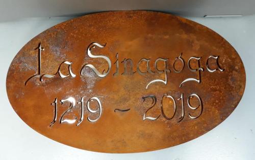 a rusty metal plate with writing on it at Sinagoga in Peñaranda de Duero