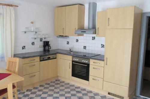 a kitchen with wooden cabinets and a stove top oven at Appartment Brigitte in Bad Gastein