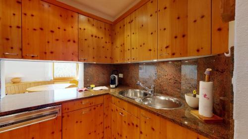 uma cozinha com armários de madeira e uma pia em Abitaziun Murinella - Pontresina em Pontresina
