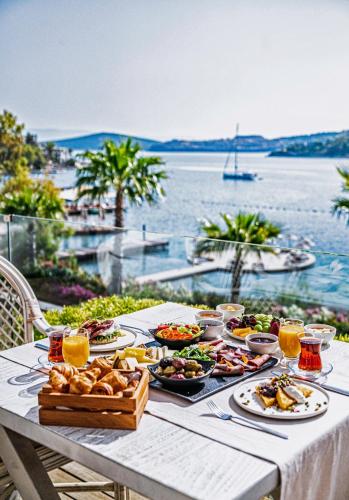 京多安Cape Bodrum Luxury Hotel & Beach的一张有食物和水景的桌子
