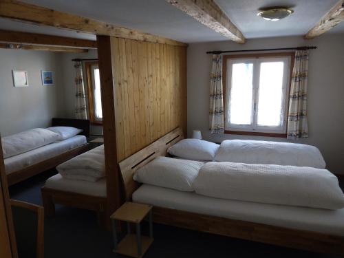 een kamer met 4 bedden en een raam bij Hotel Gotthard in Göschenen