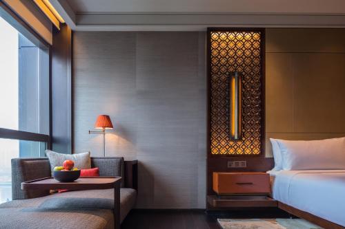 a hotel room with a bed and a table with a bowl of fruit at Regent Chongqing - Complimentary 1st round mini bar daily in Chongqing
