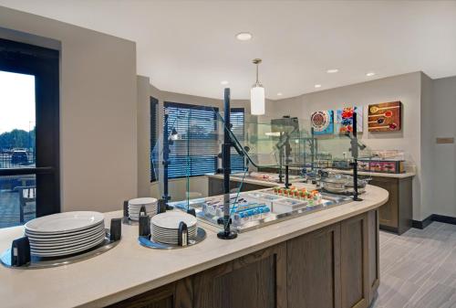 a kitchen with a counter with plates on it at Staybridge Suites Sterling Heights - Detroit by IHG in Sterling Heights