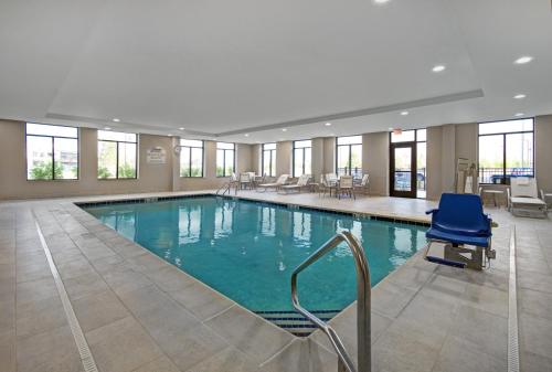 a large pool with a blue chair in a hotel room at Staybridge Suites - Sterling Heights -Detroit Area, an IHG Hotel in Sterling Heights
