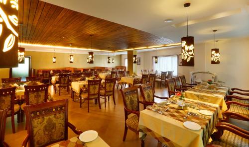a restaurant with tables and chairs in a room at Spice Grove in Thekkady