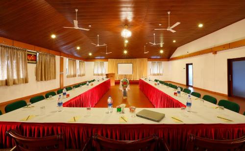 a large meeting room with a long table with red chairs at Spice Grove in Thekkady