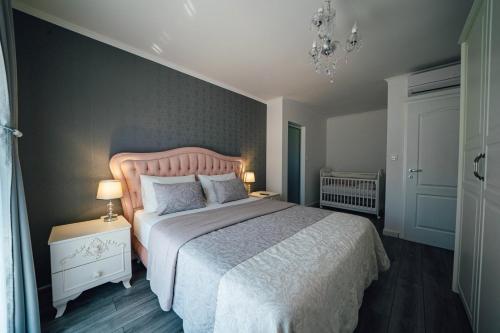 Un dormitorio con una cama grande y una lámpara de araña. en Luxury villa Tori in Imotski, pool en Lokvičič