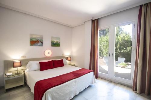 - une chambre avec un grand lit et une porte coulissante en verre dans l'établissement Hospedium Hotel Apartamentos Simón Verde, à Mairena del Aljarafe