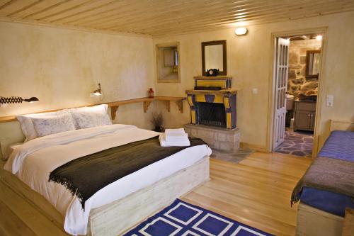 a bedroom with a large bed and a fireplace at Papaevangelou Hotel in Papigko