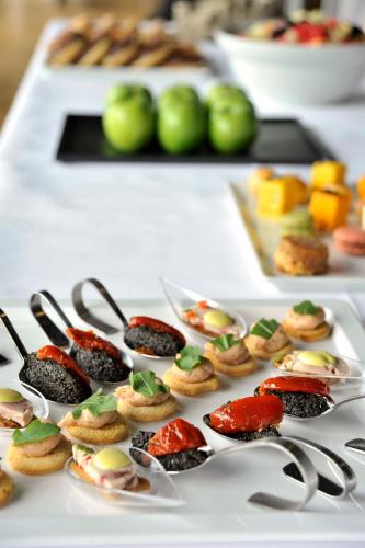 a table topped with plates of desserts and spoons at Crowne Plaza Frankfurt Congress Hotel by IHG in Frankfurt/Main