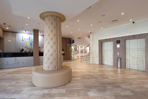 a lobby with a column in the middle of a building at Hotel Puerta de Toledo in Madrid
