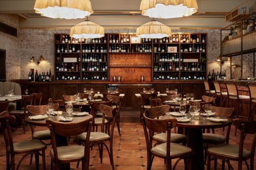 a restaurant with tables and chairs and wine bottles at The Hoxton, Holborn in London