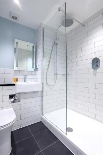 a bathroom with a shower and a toilet and a sink at London Chigwell Prince Regent Hotel, BW Signature Collection in London