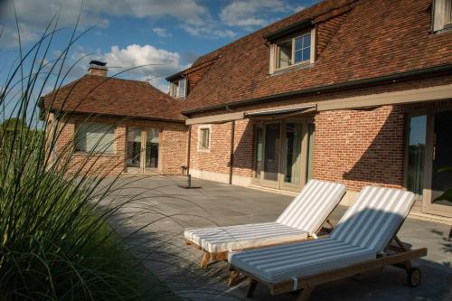 two chairs sitting on a patio in front of a house at B&B Sett in Horebeke