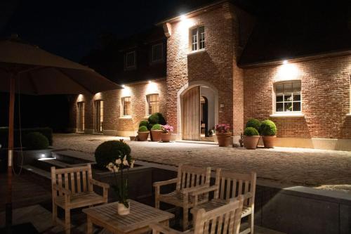 a building with chairs and a table and lights at B&B Sett in Horebeke