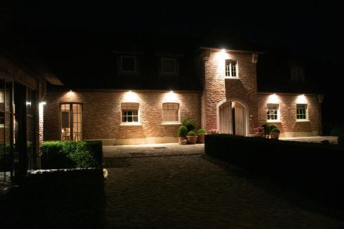a brick house at night with lights on it at B&B Sett in Horebeke