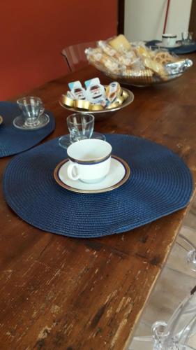 un tavolo con una tazza di caffè su un tappetino da golf blu di Casa Castagna a Caserta