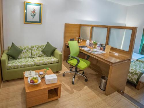 a room with a desk and a couch and a bed at The Orchid Hotel Hinjewadi Pune in Pune