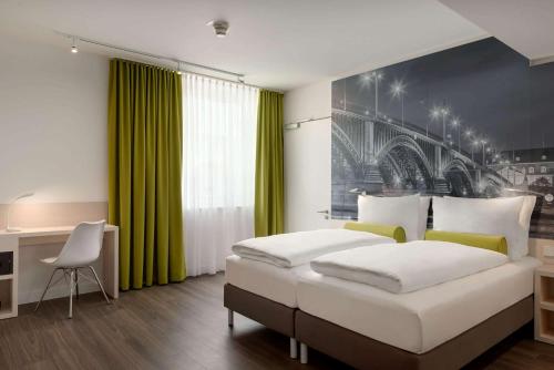 ein Schlafzimmer mit einem großen Bett und einer grünen Wand in der Unterkunft Super 8 by Wyndham Mainz Zollhafen in Mainz