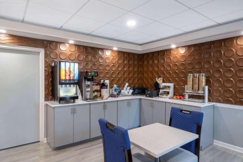 a kitchen with a table and a table and chairs at Wingate by Wyndham Horn Lake Southaven in Horn Lake
