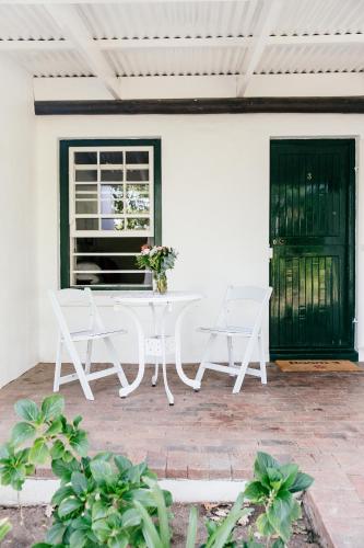 a white table and chairs on a patio at Knorhoek Country Guesthouse in Stellenbosch