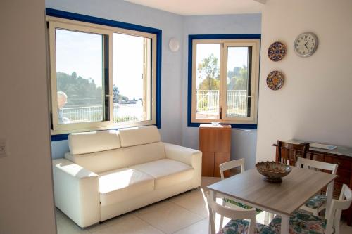 - un salon avec un canapé blanc et une table dans l'établissement Taormina Isola bella suite, à Taormine