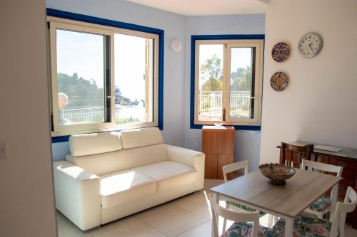 a living room with a white couch and a table at Taormina Isola bella suite in Taormina
