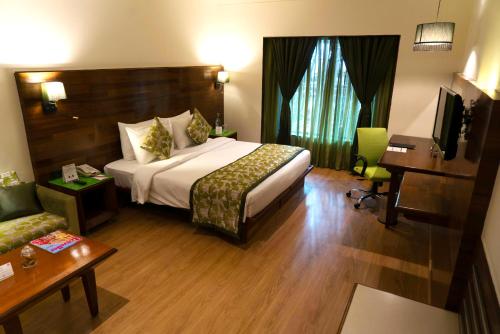 a hotel room with a bed and a desk at The Orchid Hotel Hinjewadi Pune in Pune