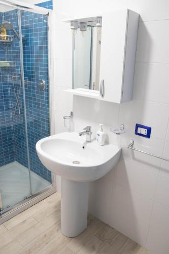 a white bathroom with a sink and a shower at Taormina Isola bella suite in Taormina