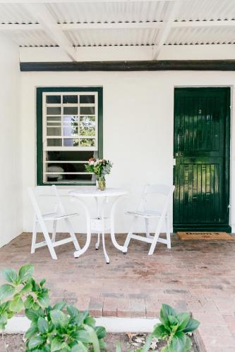 a white table and chairs on a patio at Knorhoek Country Guesthouse in Stellenbosch