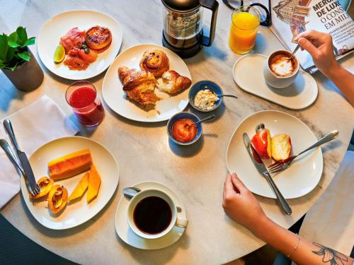 a table with plates of food and a cup of coffee at Fairmont Rio de Janeiro Copacabana in Rio de Janeiro