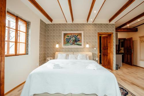 a bedroom with a large white bed in a room at Hotel Barcadam in Banská Štiavnica