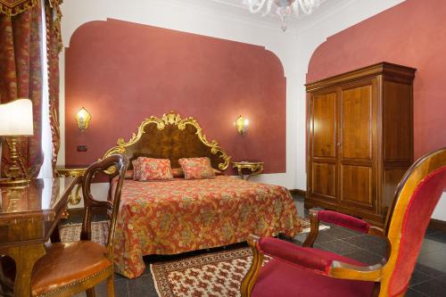 1 dormitorio con 1 cama, vestidor y sillas en Residenza d'Epoca San Cassiano, en Venecia
