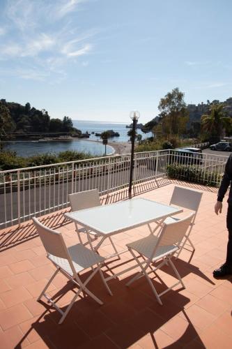 a table and chairs on a patio with a view of the water at Taormina Isola bella suite in Taormina