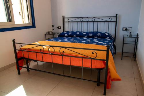 a bed with an orange and blue blanket on it at Taormina Isola bella suite in Taormina