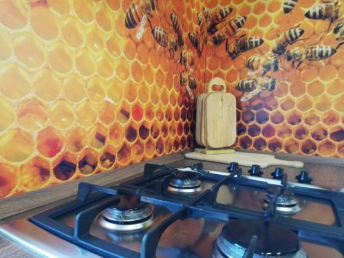 a stove top with a beehive on the wall at FeWo Gutendorf in Bad Berka