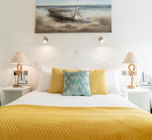 um quarto com uma cama amarela com um quadro na parede em The Addresse on the Beach em Tramore