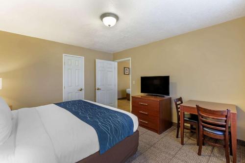 a bedroom with a bed and a desk with a television at Comfort Inn Saint George North in St. George