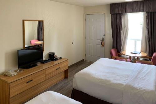 um quarto de hotel com duas camas e uma televisão em Rodeway Inn em Edson
