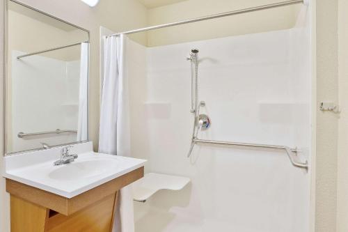 ein weißes Bad mit einem Waschbecken und einer Dusche in der Unterkunft WoodSpring Suites Gainesville I-75 in Gainesville