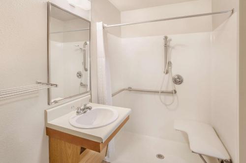 泰勒的住宿－WoodSpring Suites Tyler Rose Garden，白色的浴室设有水槽和淋浴。
