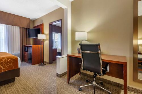 a hotel room with a bed and a desk and a chair at Comfort Suites in Marquette