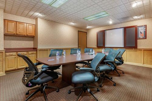 a conference room with a table and chairs and a screen at Comfort Suites in Marquette